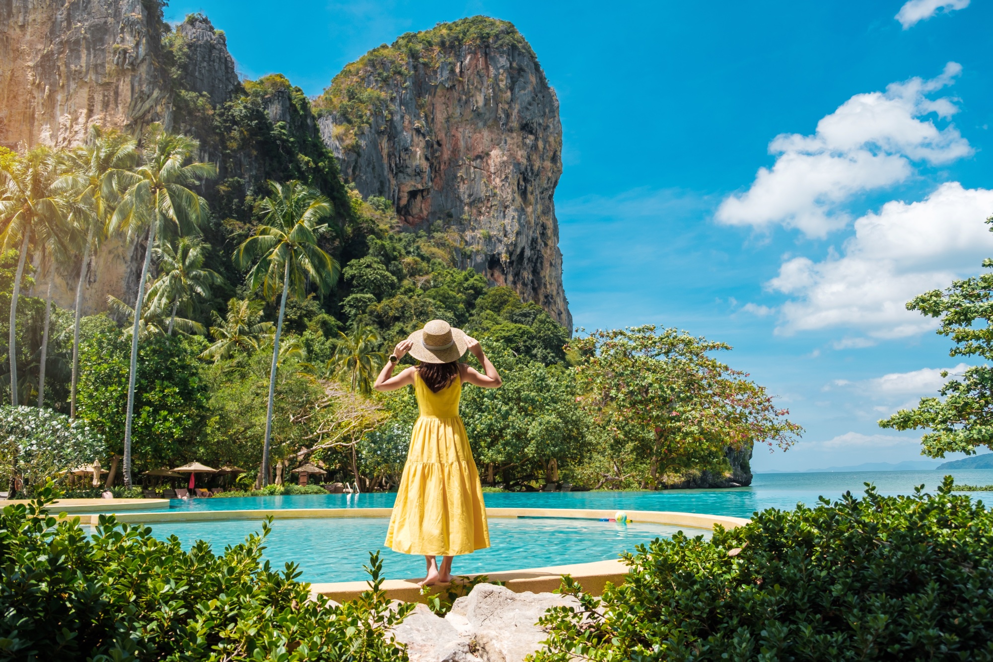 Woman tourist in yellow dress and hat traveling on Railay beach, Krabi, Thailand. vacation, travel, summer, Wanderlust and holiday concept