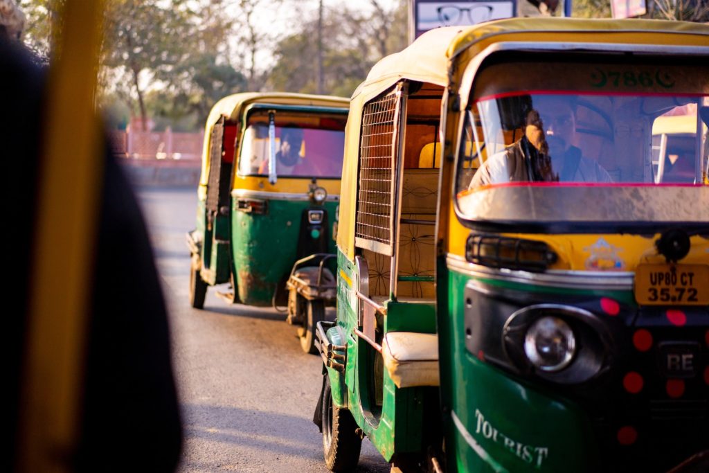 green and yellow auto rickshaw on road during daytime