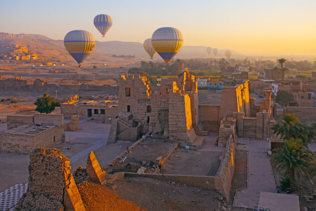 Luxor, Egypt - March 15 , 2025: Hot air balloon flying above The Mortuary Temple of Ramesses III at Medinet Habu in Theban Necropolis at Valley of the Kings, Loxor, Egypt
