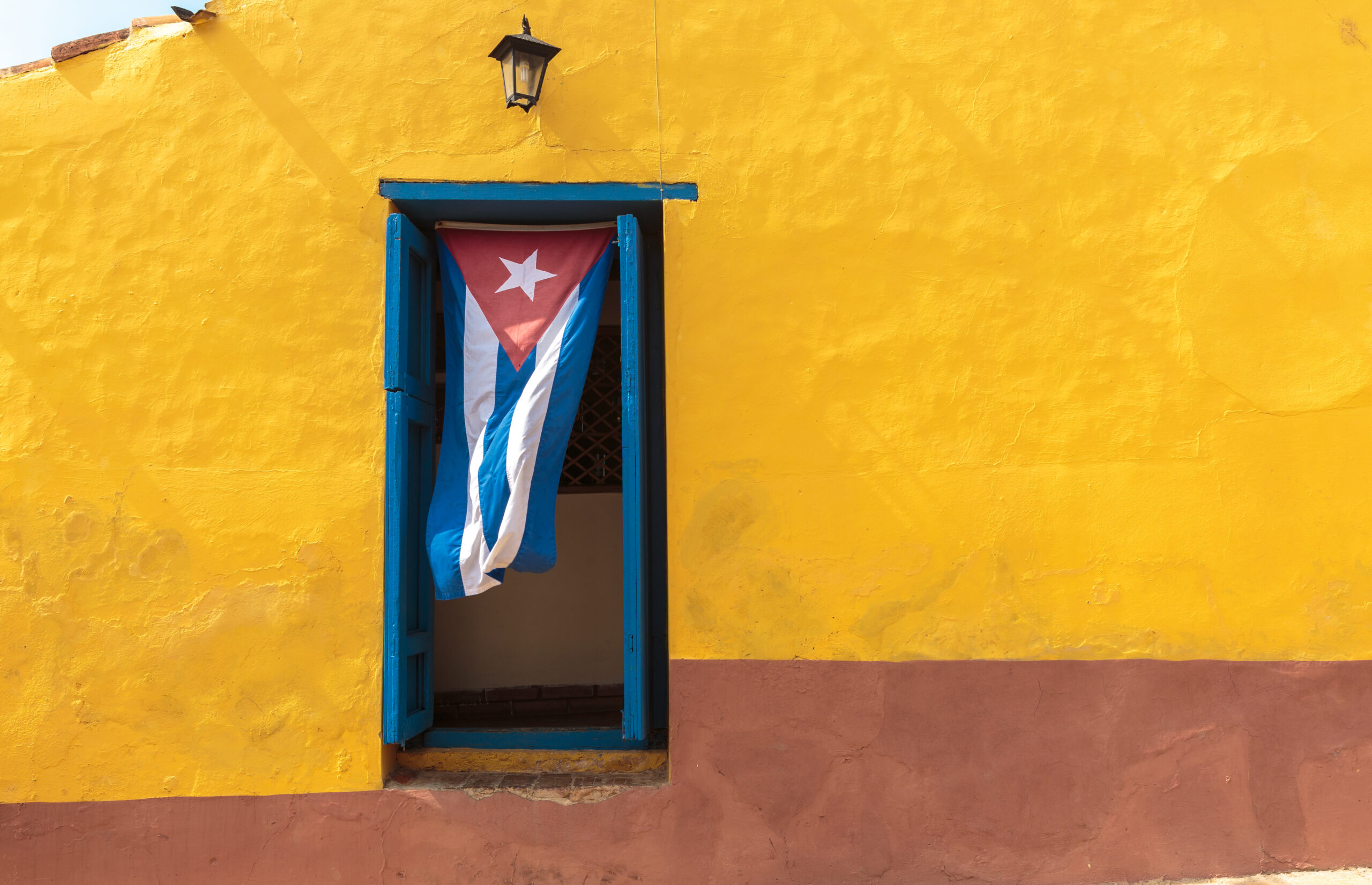 Cuban flag hanging on a door in Trinidad, Cuba