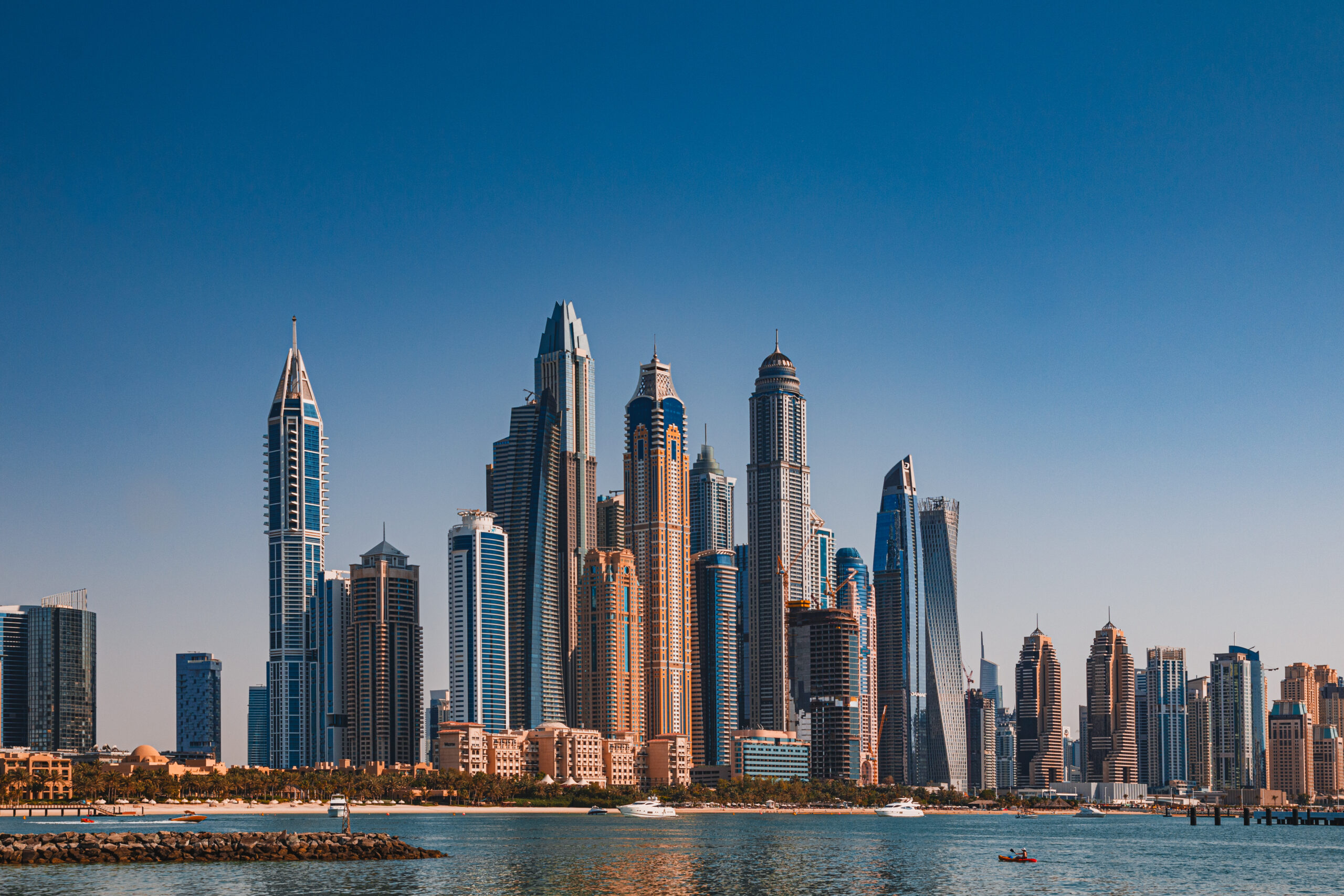 The sky reflected on modern glass skyscrapers and the sea as seen from the Palm Dubai. The buildings in the photo are located in Dubai Marina