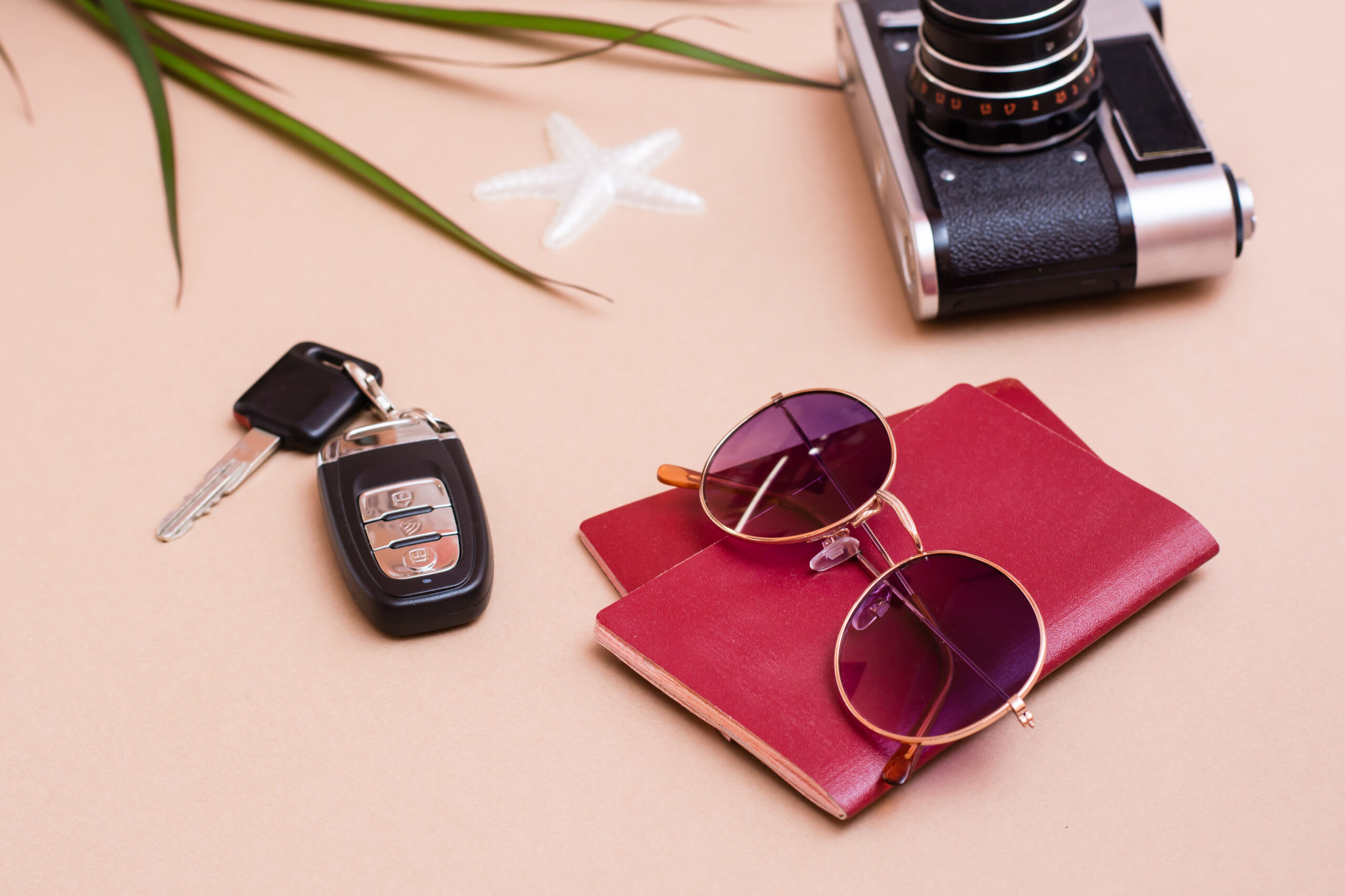 Two closed passports with car keys and sunglasses on a table